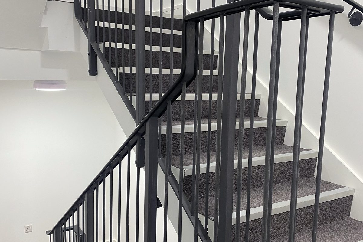 Black steel vertical bar balustrade and handrail in a stairwell